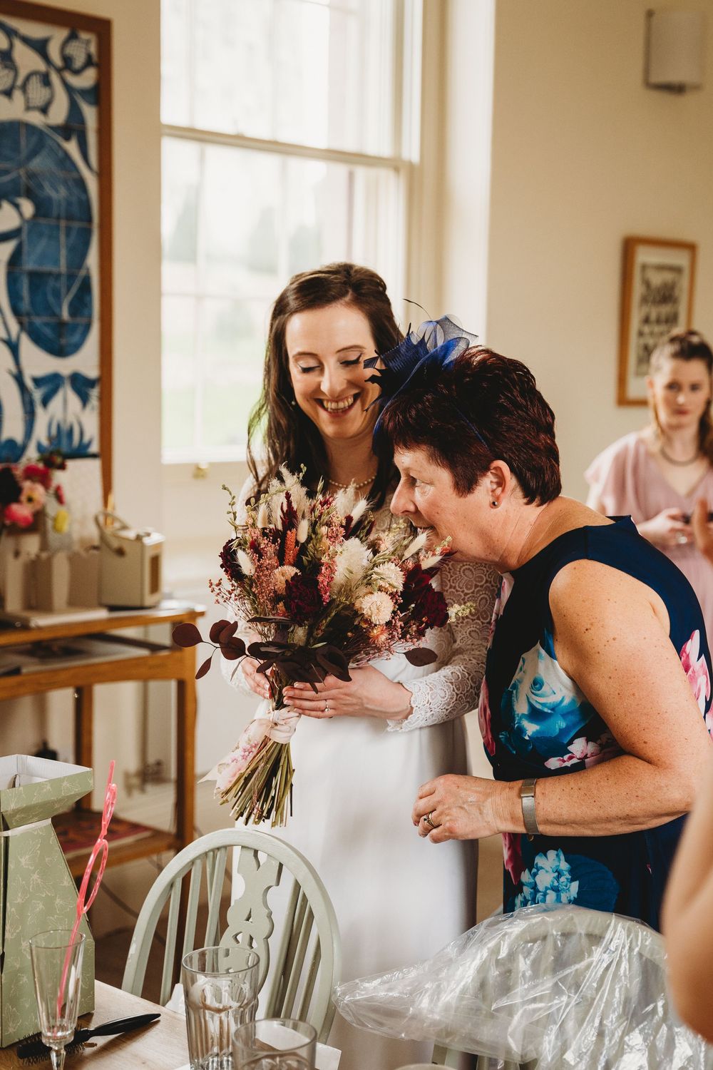 Wedding guests sharing laughter and embraces at a reception table.