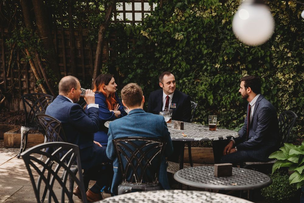 Wedding guests seated at outdoor tables during a garden reception.