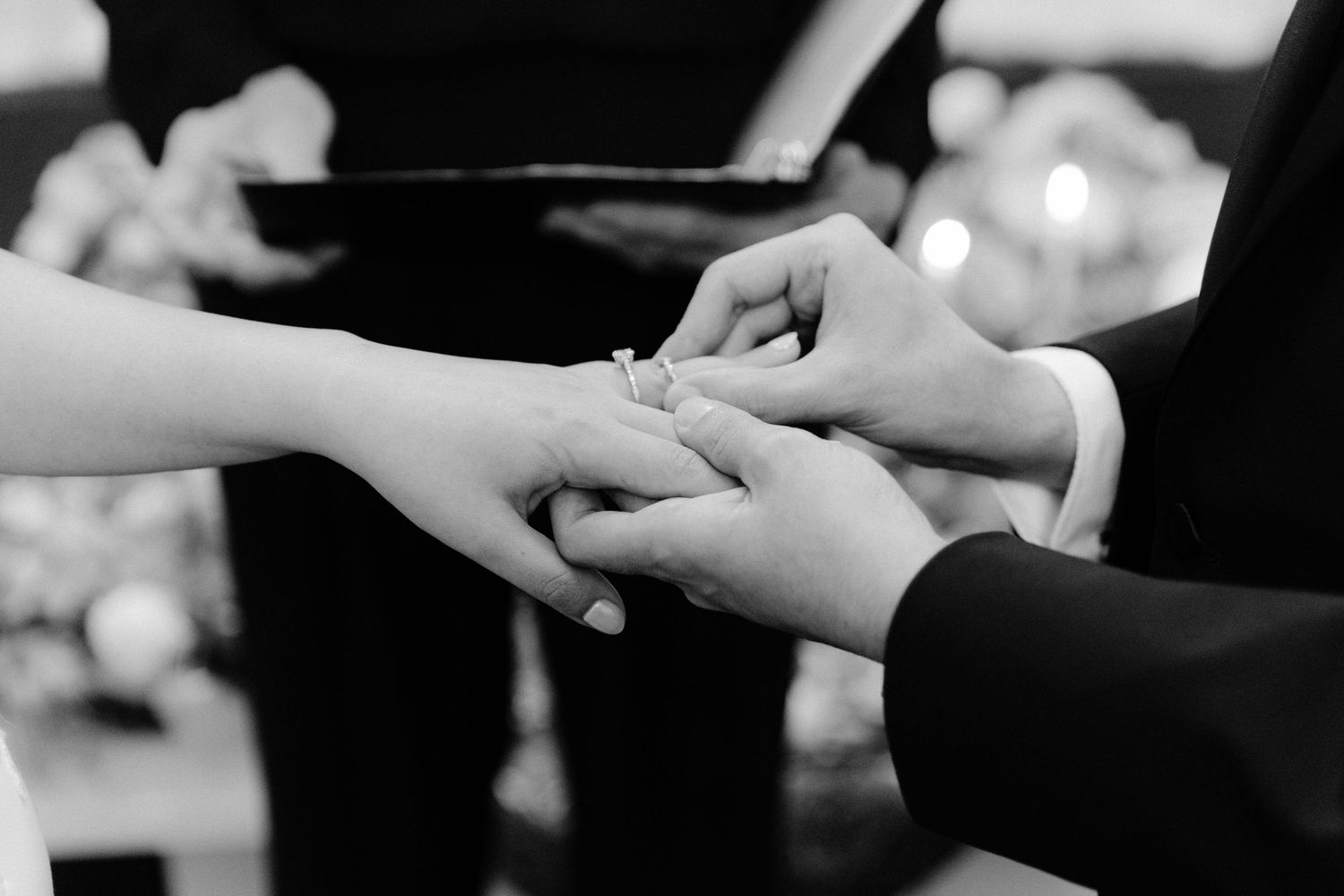 Close-up shot of hands exchanging wedding rings during a romantic ceremony.