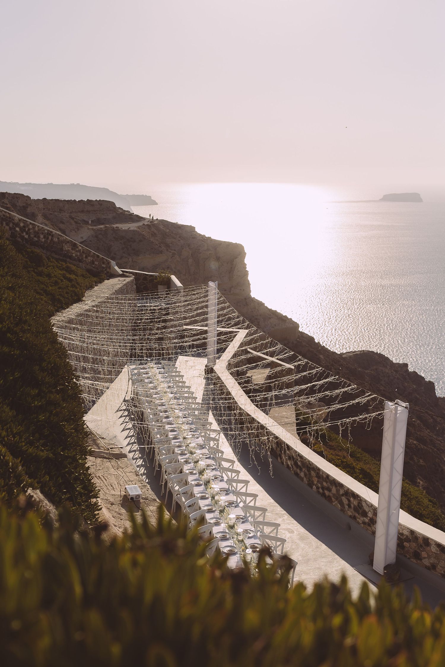 Wide view of El Viento terrace in Santorini caldera at sunset.