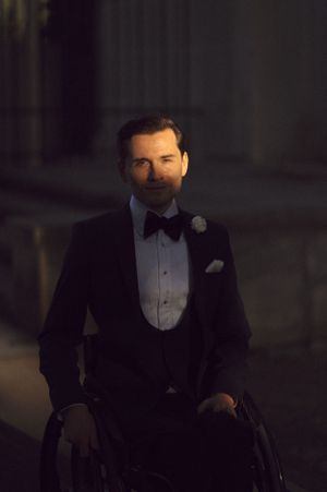 A formal portrait in evening wear with classic black bow tie and white boutonniere.