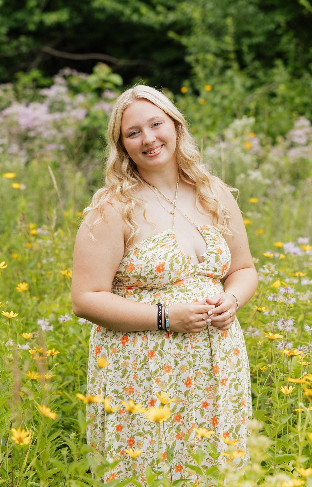 A floral sundress is worn in a vibrant wildflower meadow filled with yellow and purple blooms on a sunny summer day.