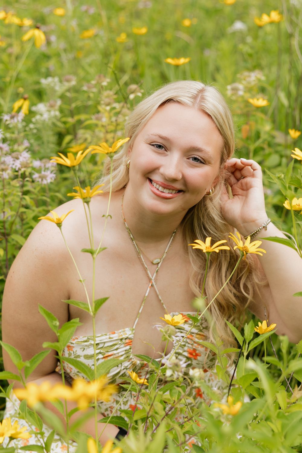 Candid portrait in a vibrant field of yellow wildflowers on a sunny summer day.