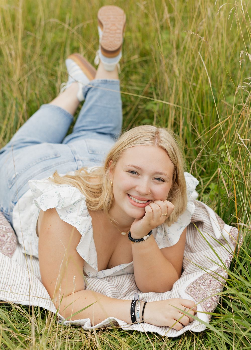A series of outdoor portraits taken in a golden grass field with white lace dress and casual denim style.
