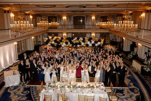 Grand ballroom wedding reception with elegant lighting and tables set for dinner.