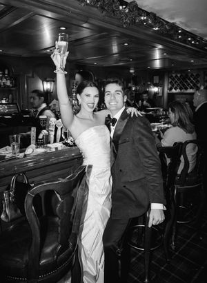 Black and white photos showing a couple dancing and celebrating in a dimly lit venue.