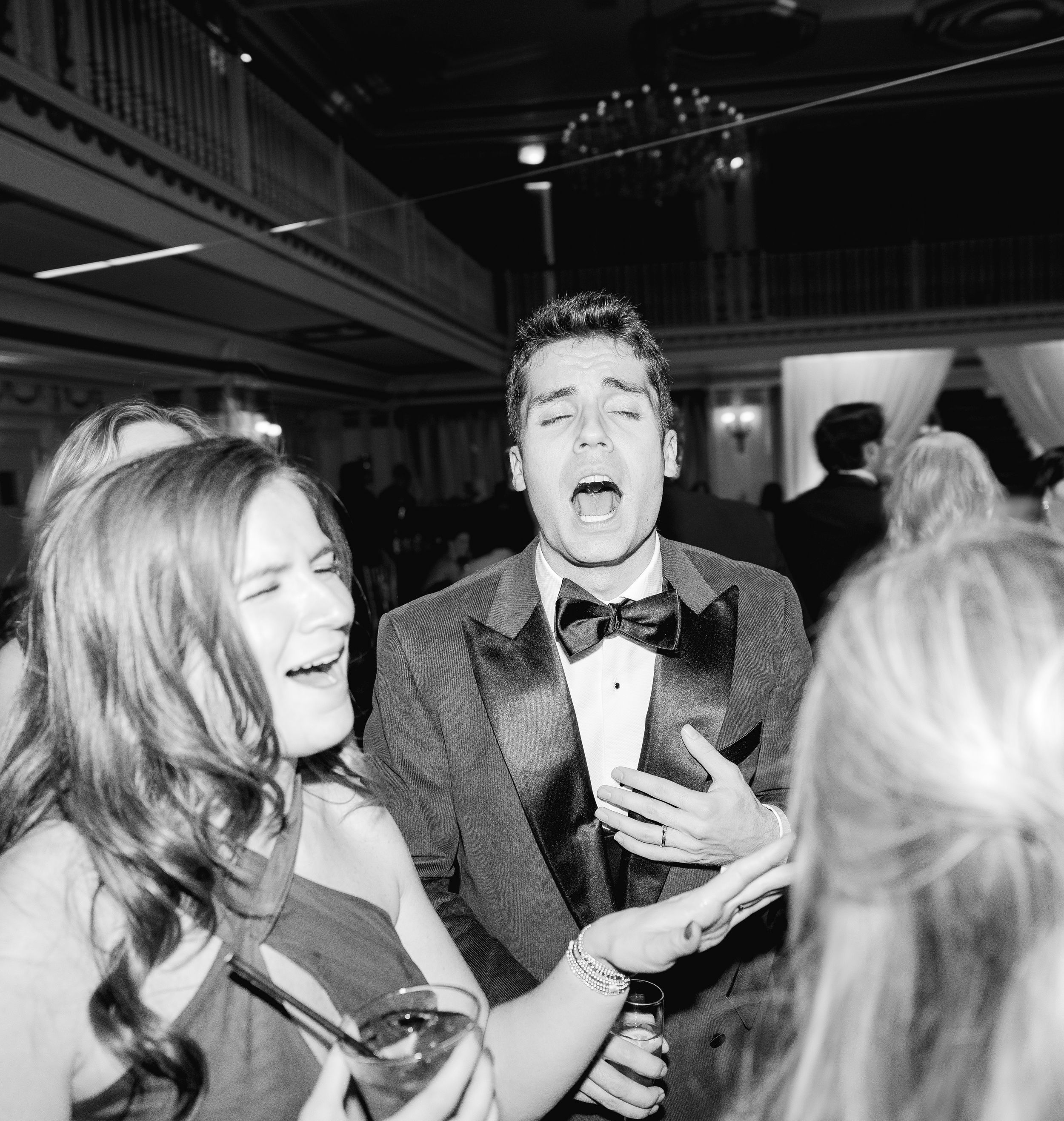 Black and white candid shots of wedding guests laughing and celebrating.