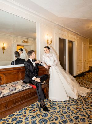 Wedding couple creates dynamic poses along The Drake hotel Chicago corridor with designer wedding attire