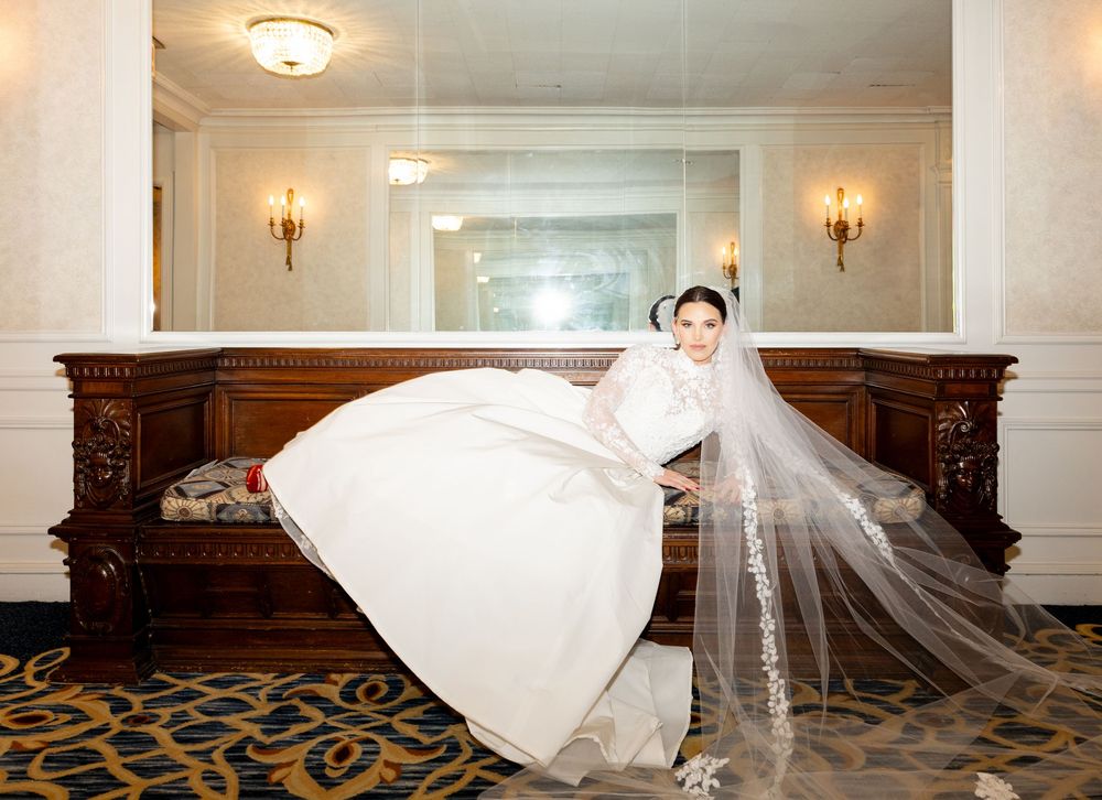 Wedding dress lays dramatically in a series of shots along a The Drake hotel Chicago corridor. Bride adorn in luxury wedding dress.