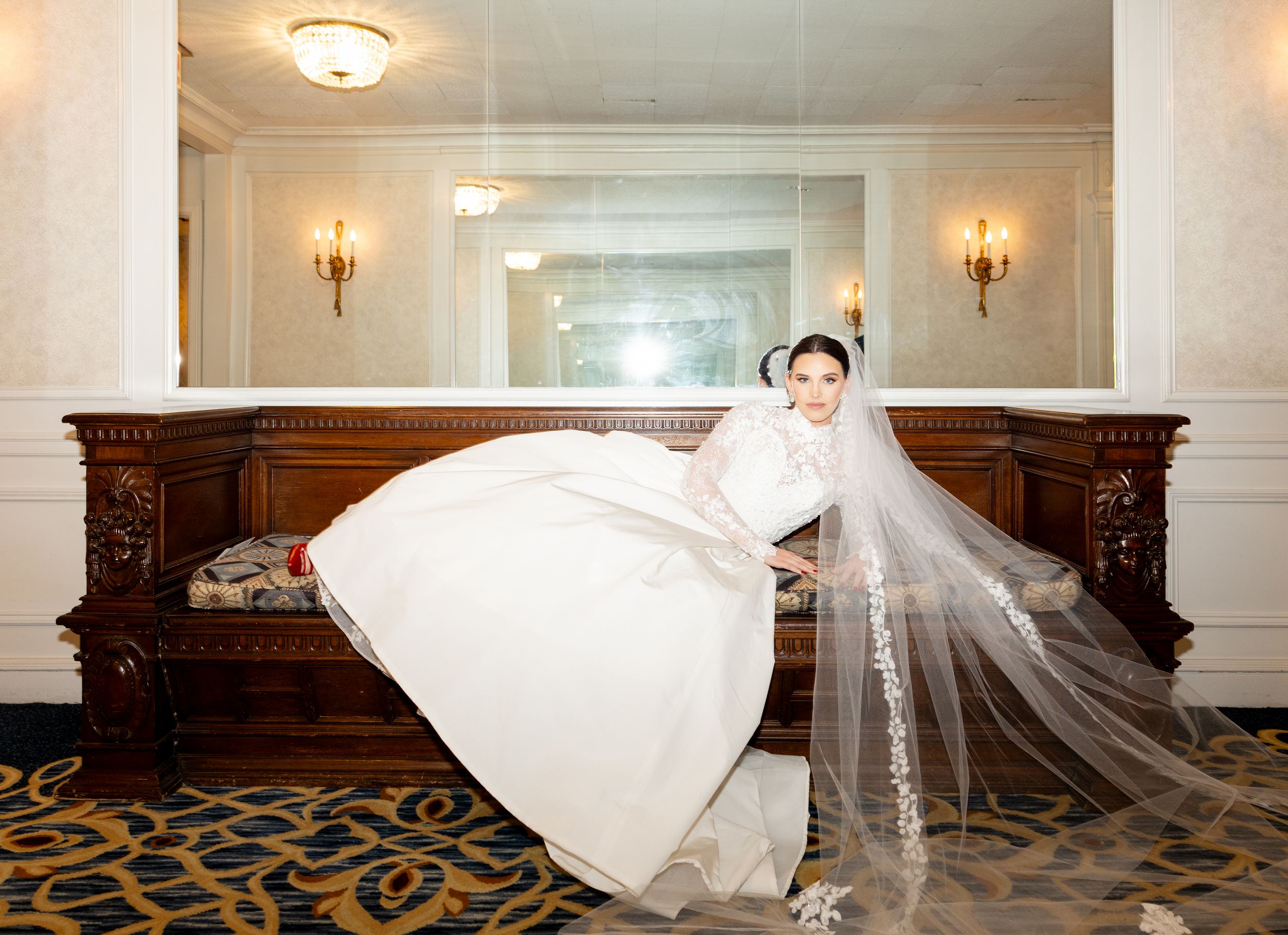 Wedding dress lays dramatically in a series of shots along a The Drake hotel Chicago corridor. Bride adorn in luxury wedding dress.