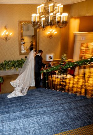 Multiple exposure photo showing the graceful movement of a bride's white dress against a dark carpeted floor.