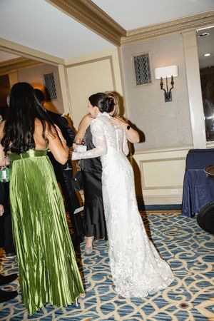 Wedding guests dancing at a reception in an elegant Drake Hoytel ballroom with patterned carpet and wall sconces.