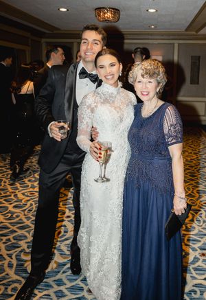 Wedding celebration in an elegant hotel ballroom with decorative carpet and formal attire.
