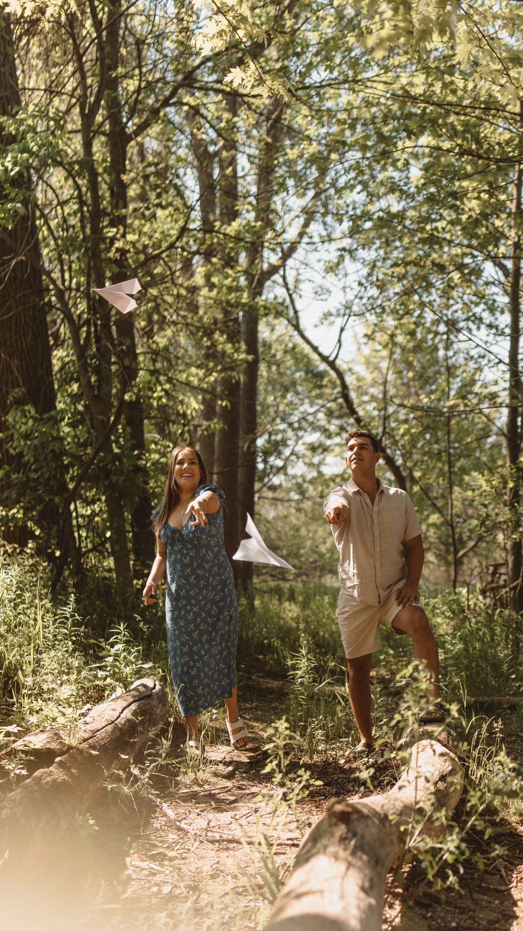 couple play with paper airplanes at a conservation area on wolfe island, near kingston ontario. things to do photo shoot