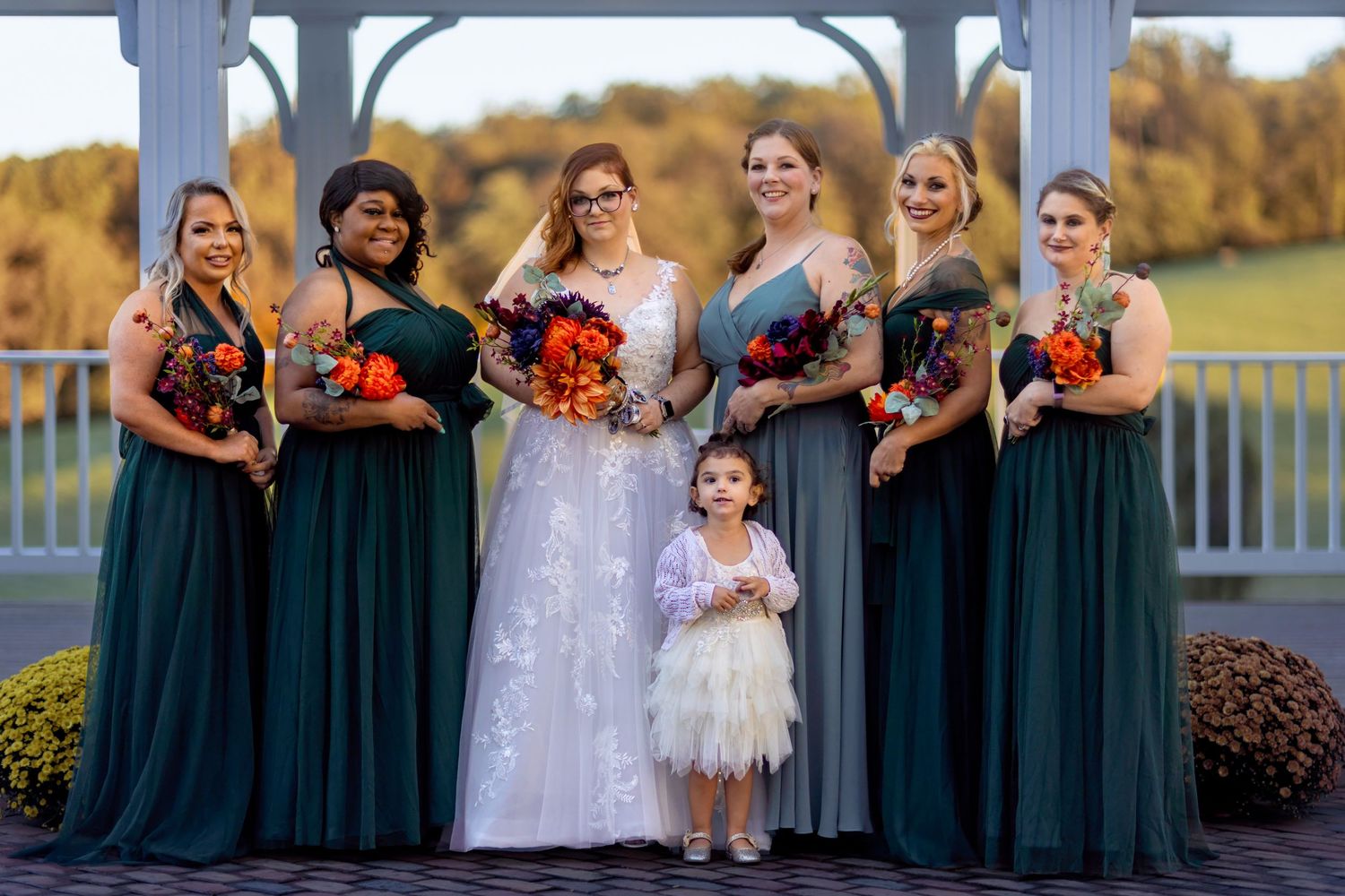 Frederick Maryland Wedding Photographer  -  Wedding party in teal dresses poses outdoors during golden hour with white gazebo in background.
