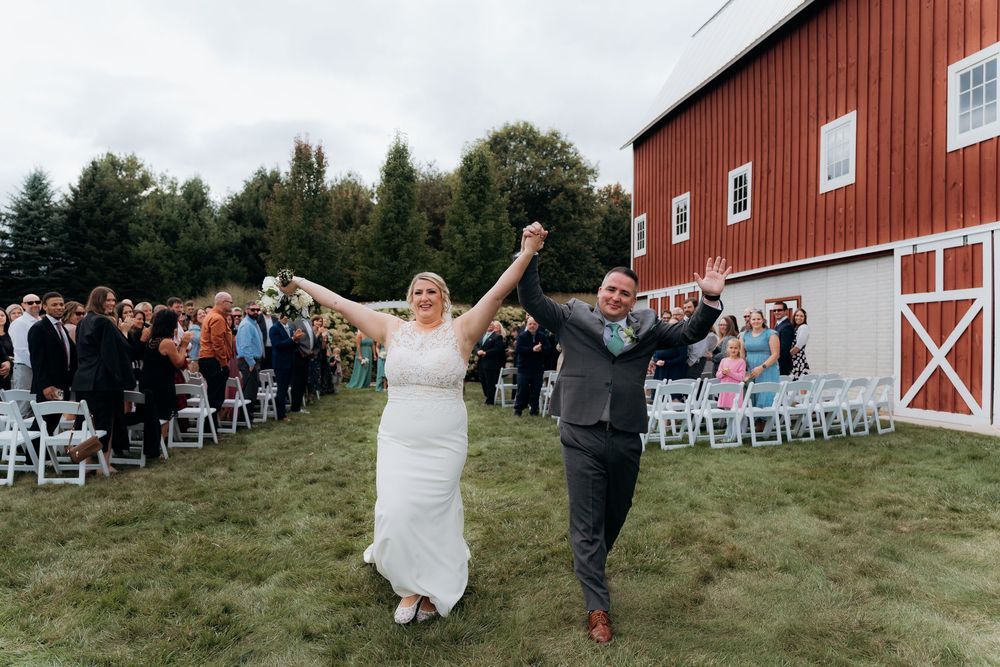 Wedding ceremony setup outside Garvey Family Wedding Barn. Family and guests celebrating. Bride and Groom celebrating.