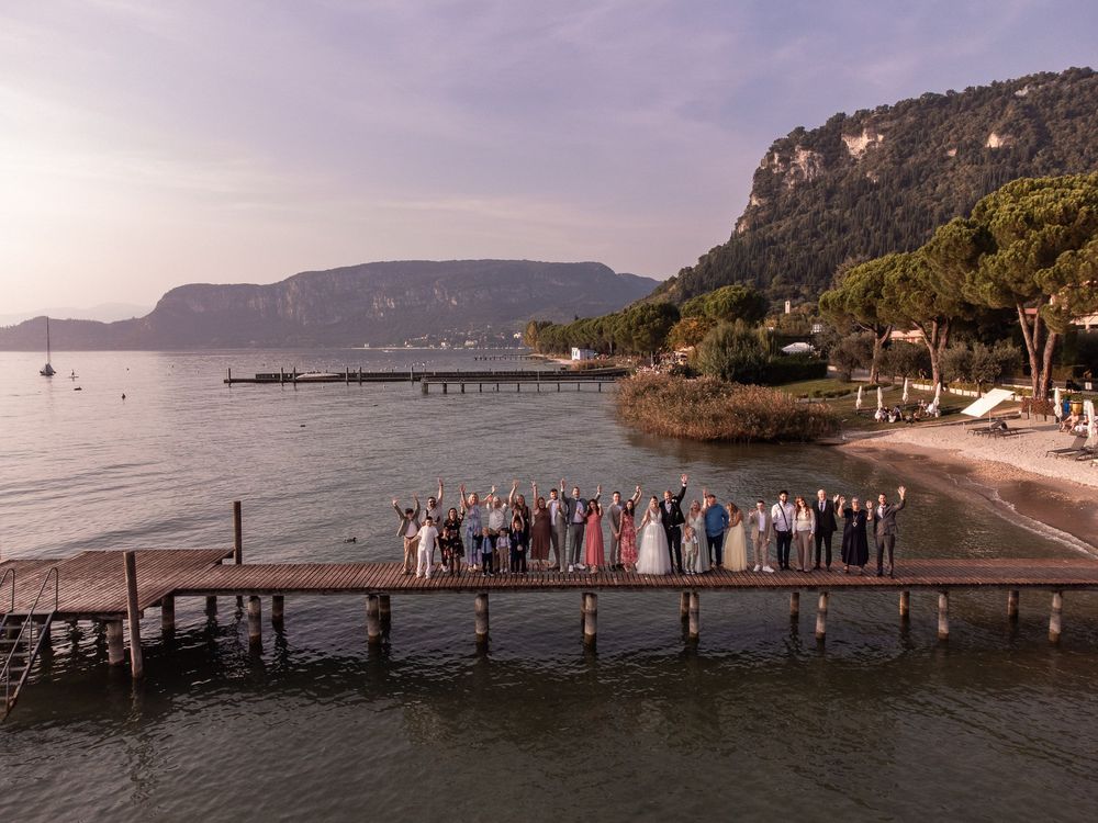 Hochzeitsgesellschaft auf einem Steg am Gardasee in Bardolino.