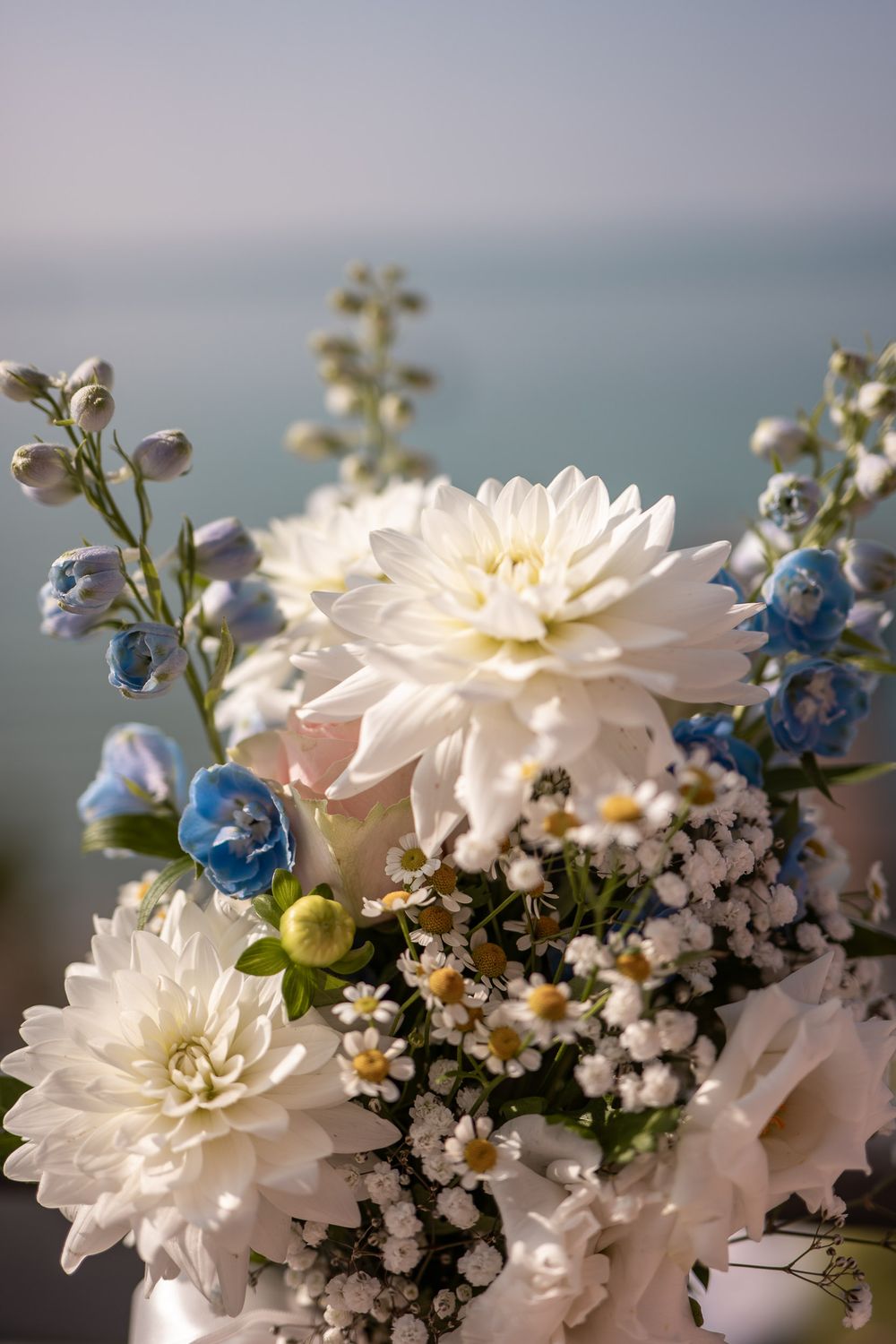 Brautstrauß mit weißen Blumen vor der Kulisse des Gardasees