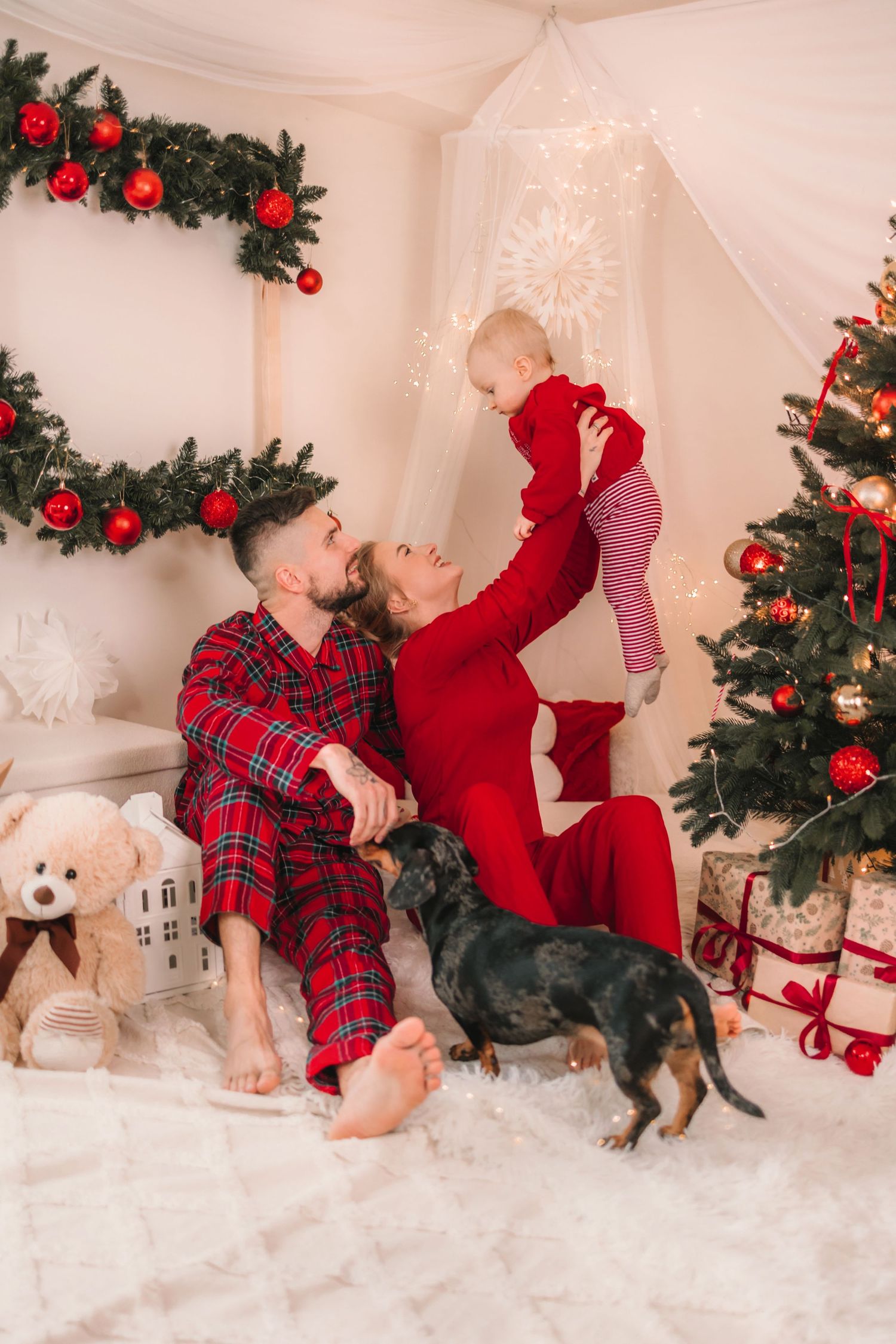 Rodinná vianočná idylka so psíkom pri stromčeku. Profesionálny vianočný fotograf Žilinský kraj.