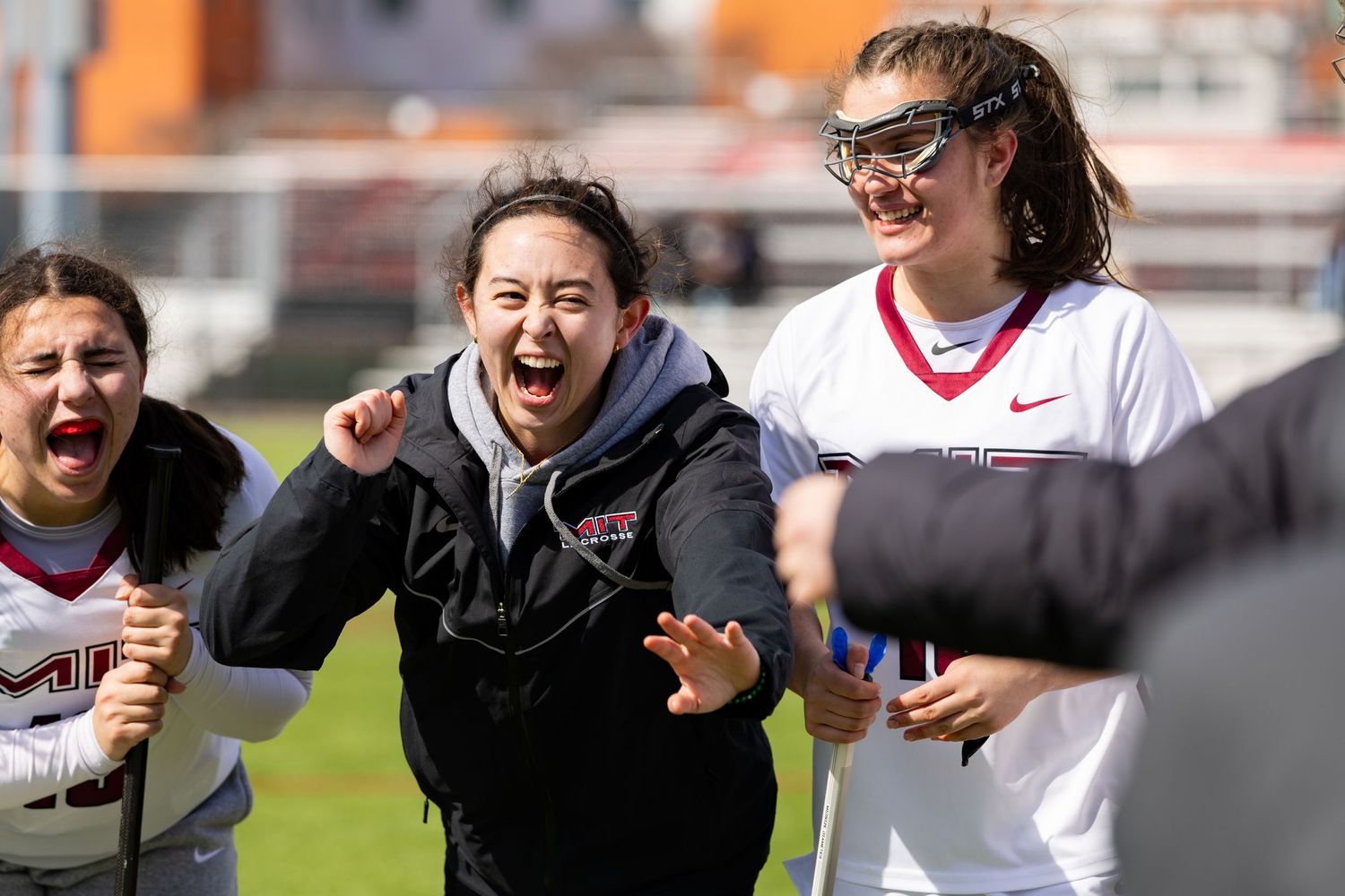 Soccer players celebrate enthusiastically on a sunny field during a match.