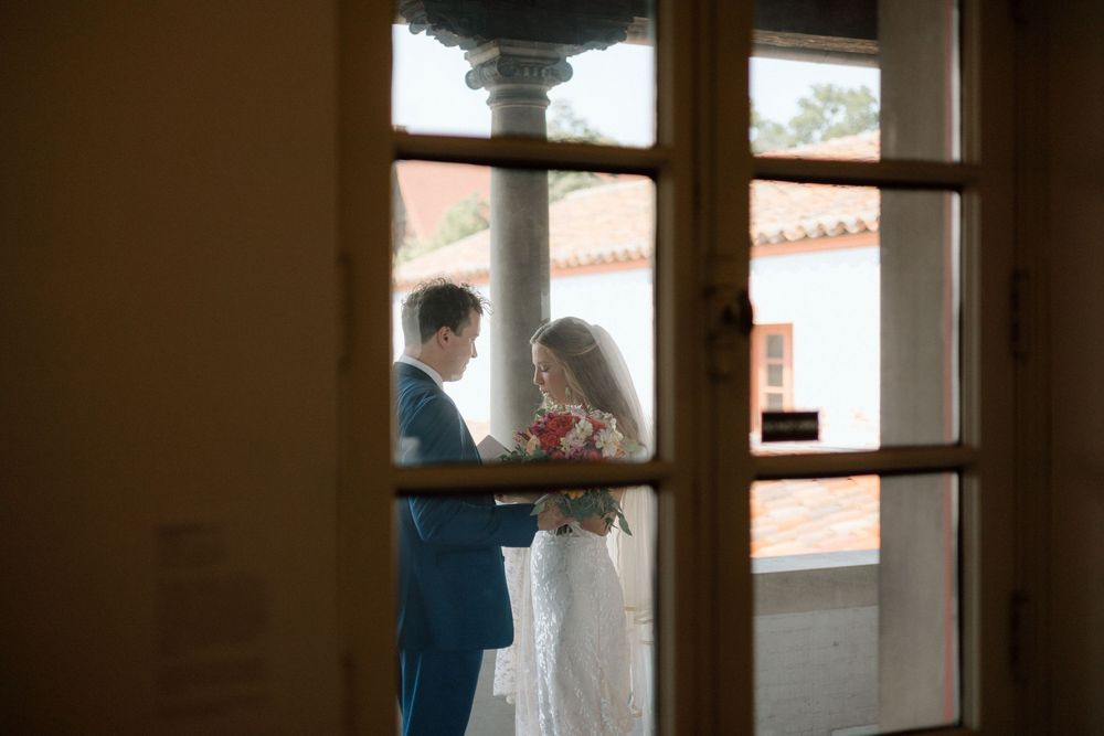 Silhouettes of figures seen through window panes in an elegant historic building.