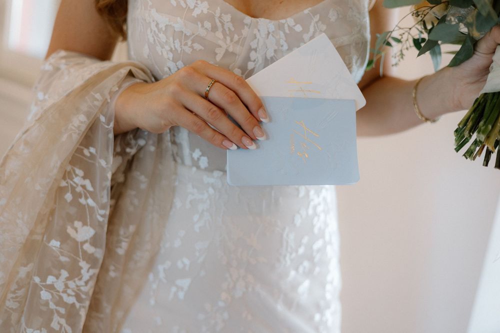 Close-up details of a delicate lace wedding dress with floral embroidery patterns.