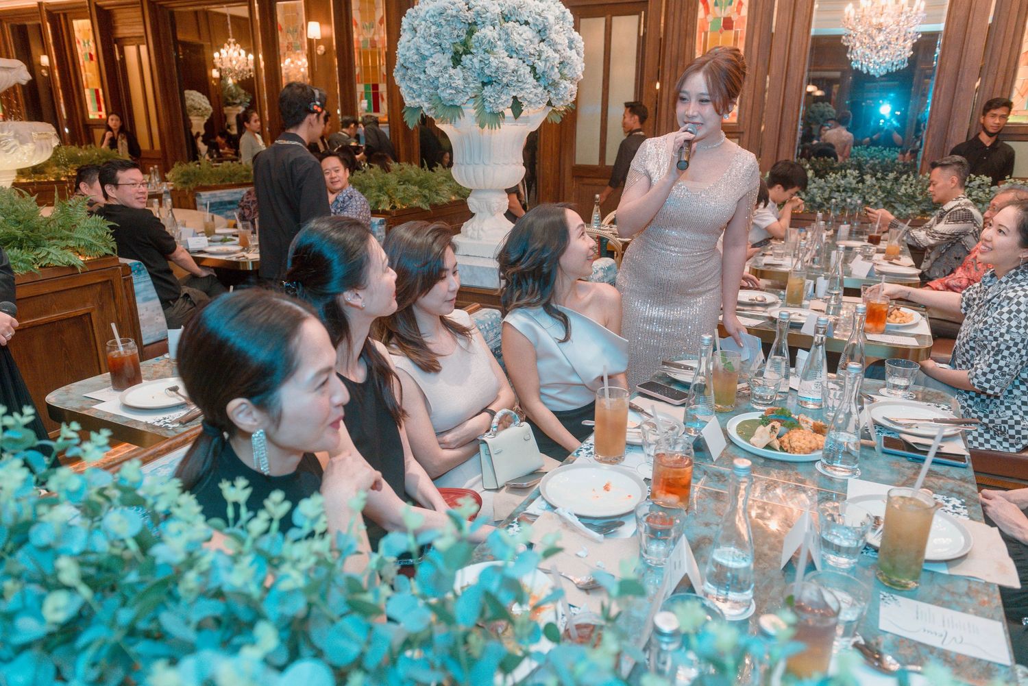 A collage of people enjoying a formal dinner party with blue floral decorations and table settings in an elegant dining room.
