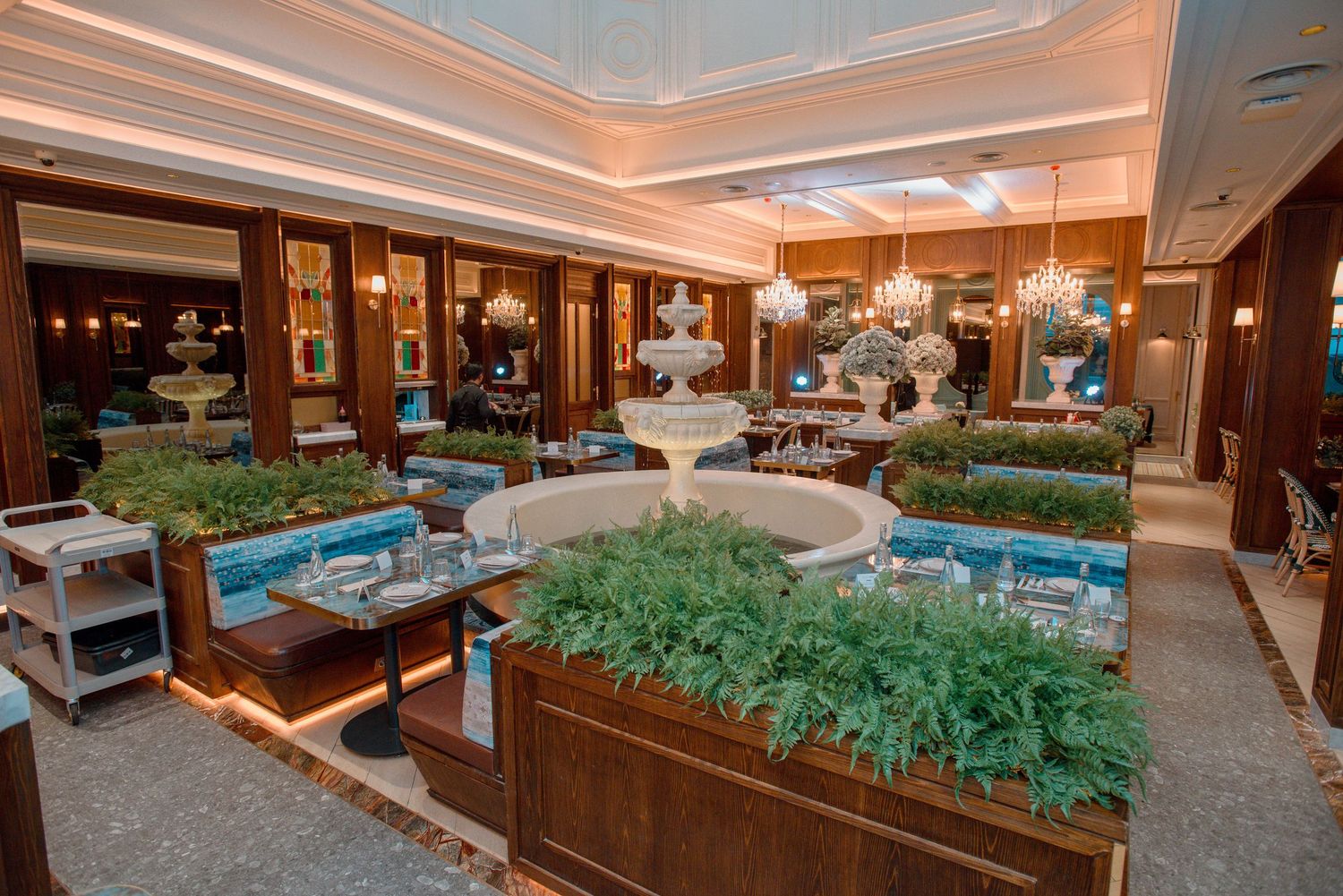 Panoramic view of an upscale restaurant interior with wooden furnishings and turquoise decorative elements.