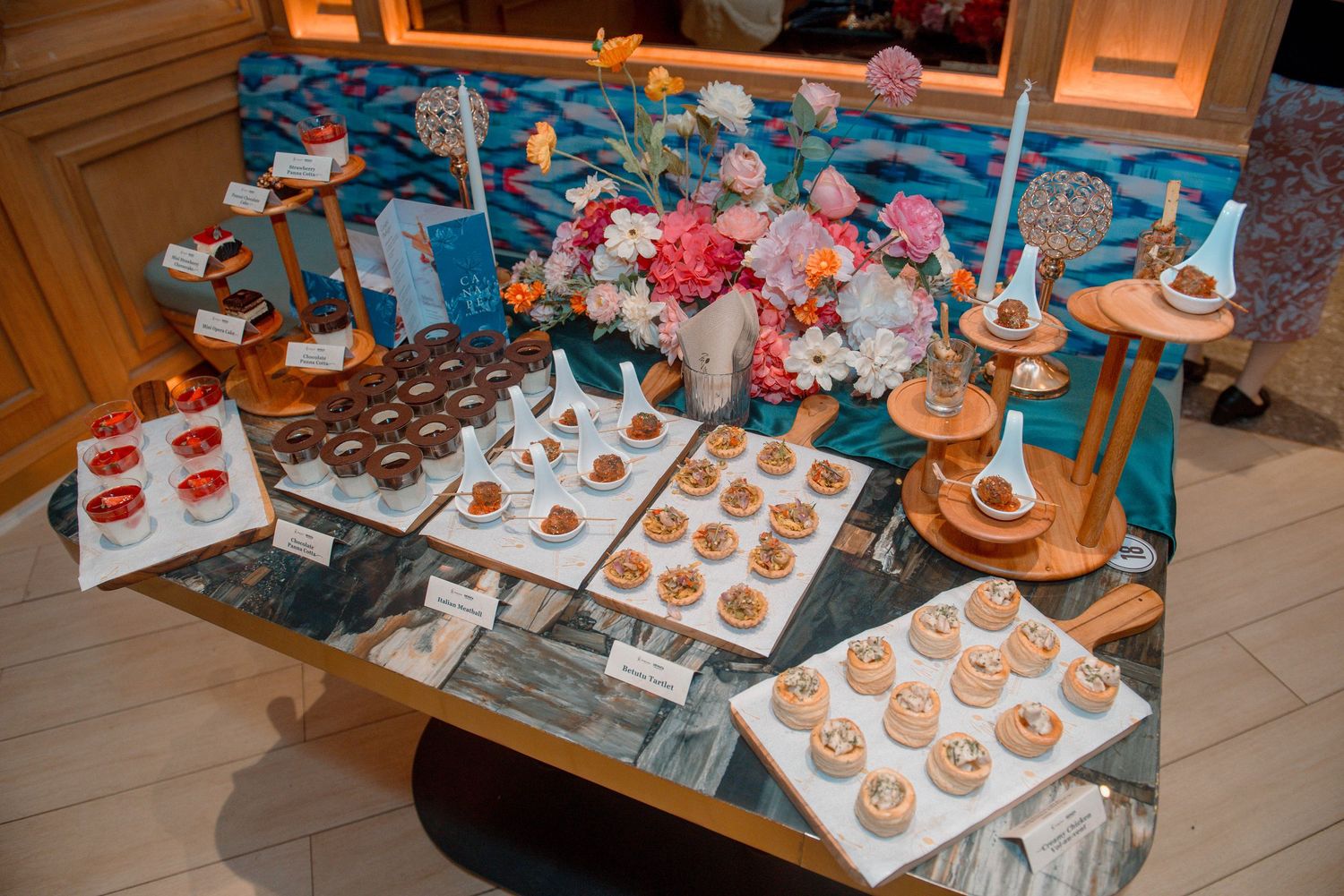 Rows of freshly baked pumpkin-shaped sugar cookies with orange icing being decorated on cooling racks.