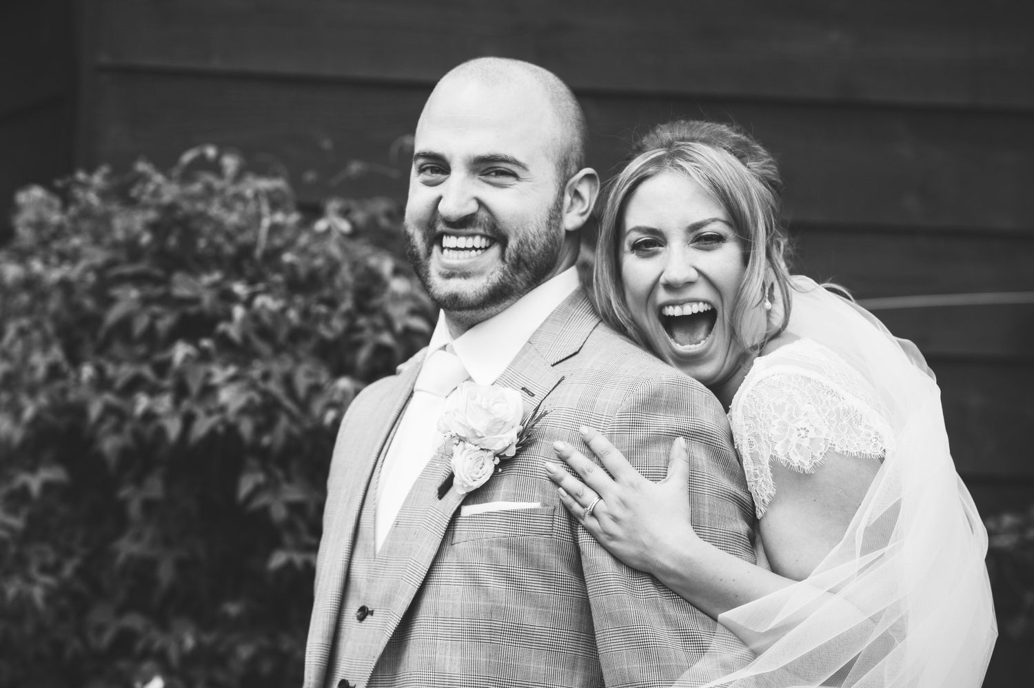 A joyful wedding couple shares candid laughing moments together in a series of black and white photographs.