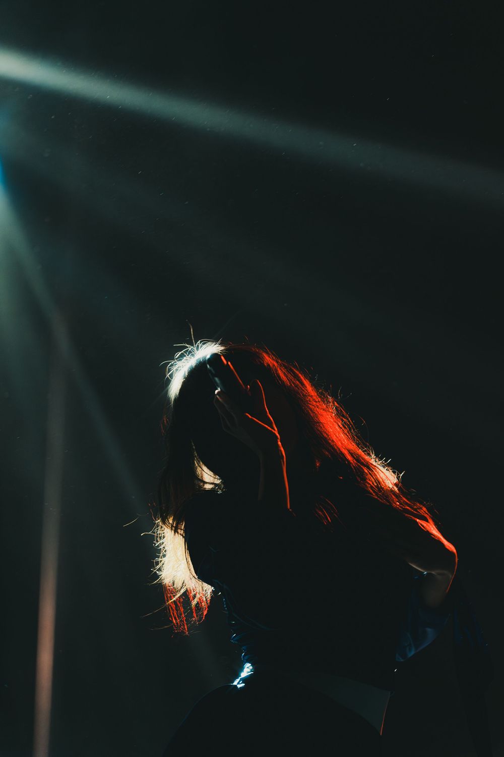 A series of dark silhouettes against a black background with red and blue light accents creating a dramatic mood.