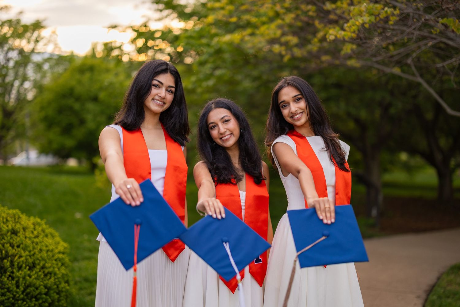 Three UIUC graduating girls holding their caps at Japan House with white dresses