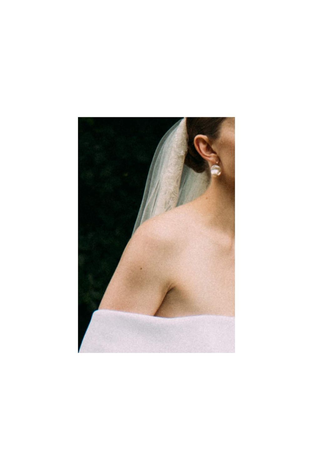 The image shows a woman's shoulder and back, with a veil draped over her head, creating a soft, ethereal look.
