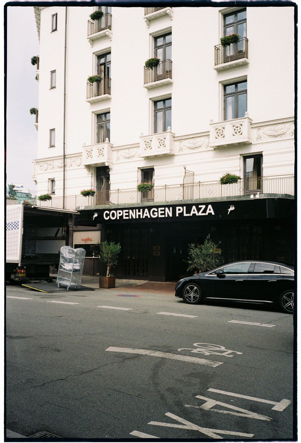 Exterior view of Copenhagen Plaza building with parking spaces in front on an empty street.