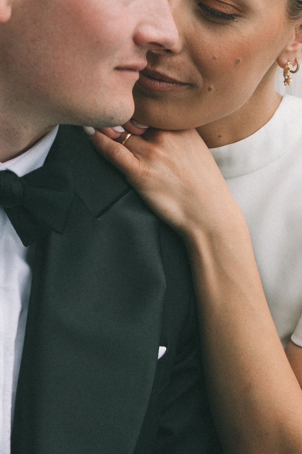 Close up view of a romantic wedding couple sharing an intimate moment together in formal attire.
