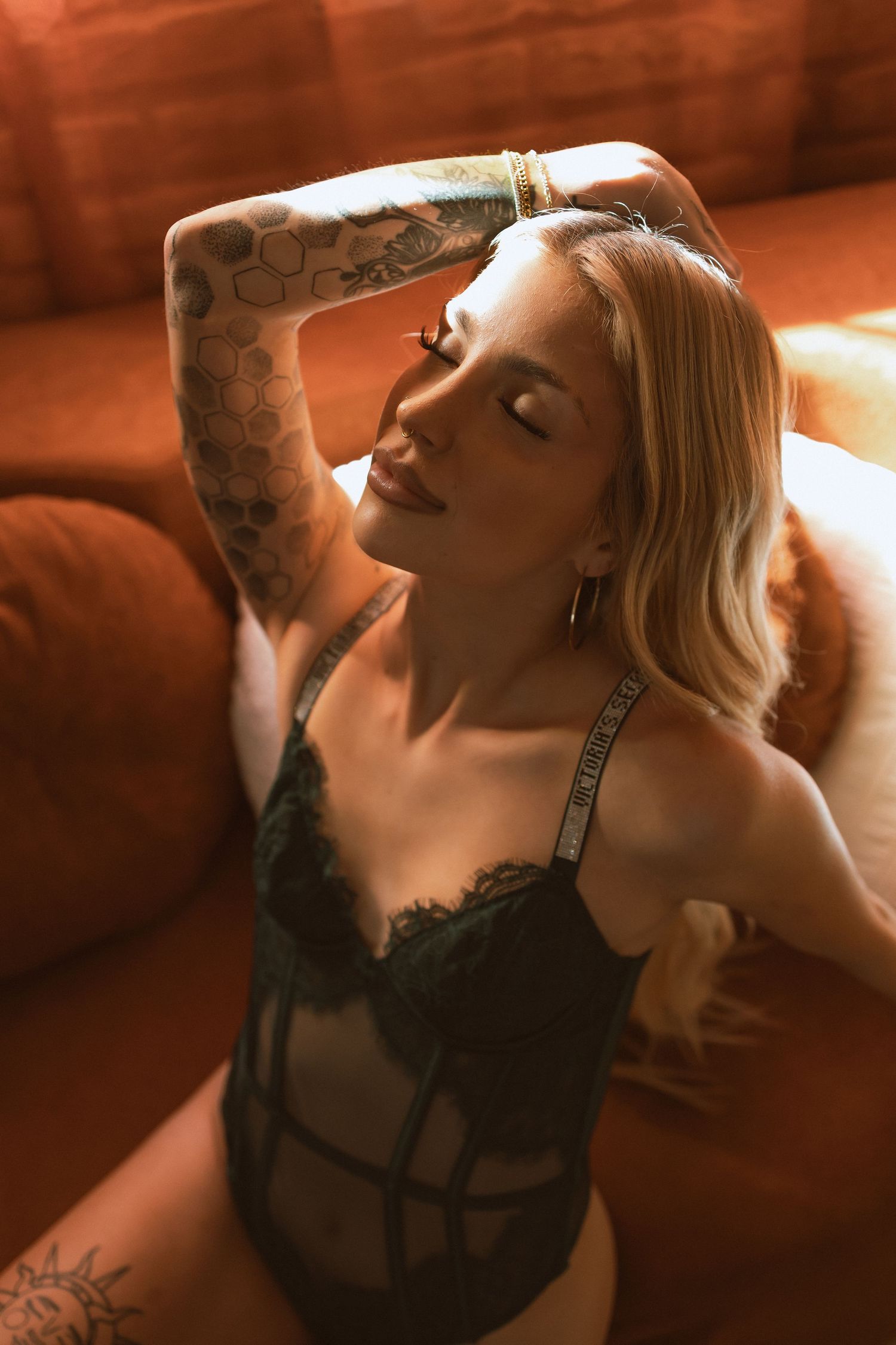 Artistic boudoir photo series in warm sepia tones showing intimate poses and shadows against a dark background.