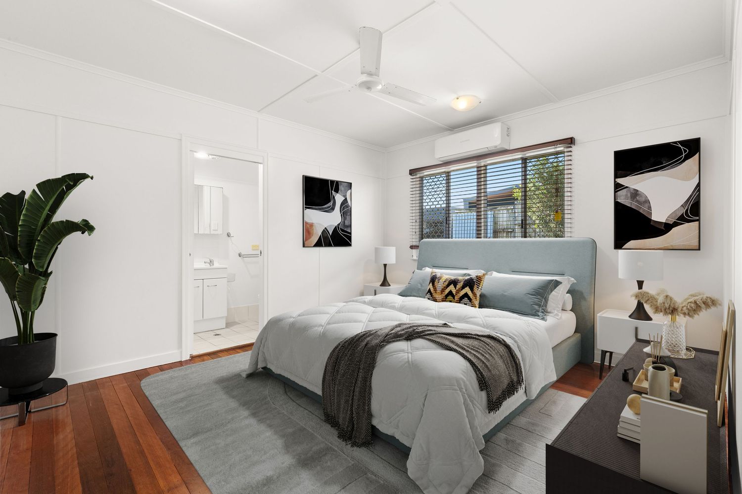 Spacious bedroom with hardwood floors, air conditioning, and ensuite bathroom access.