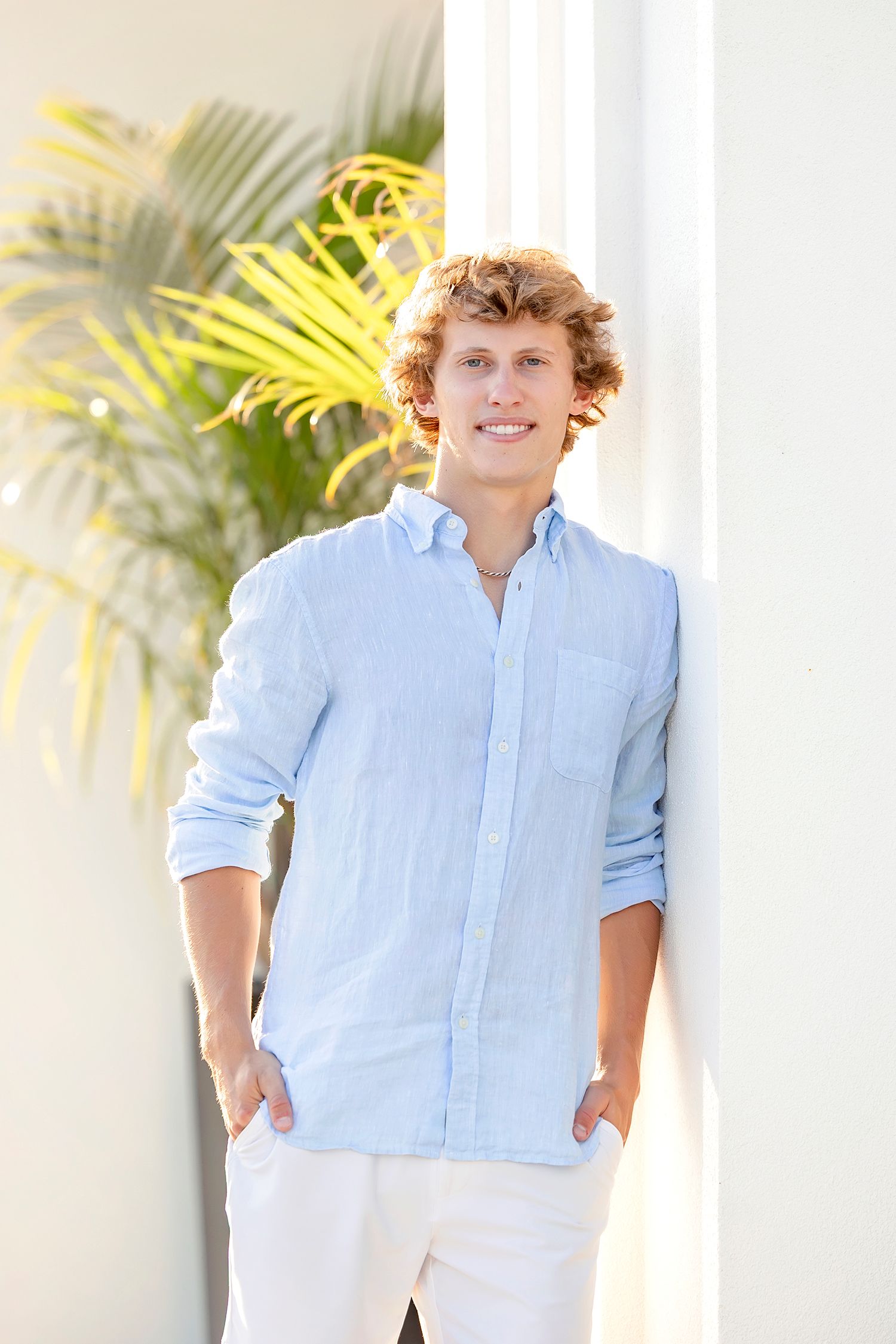 High school senior boy standing at The Palms walkway during Clear Lake Iowa senior photos