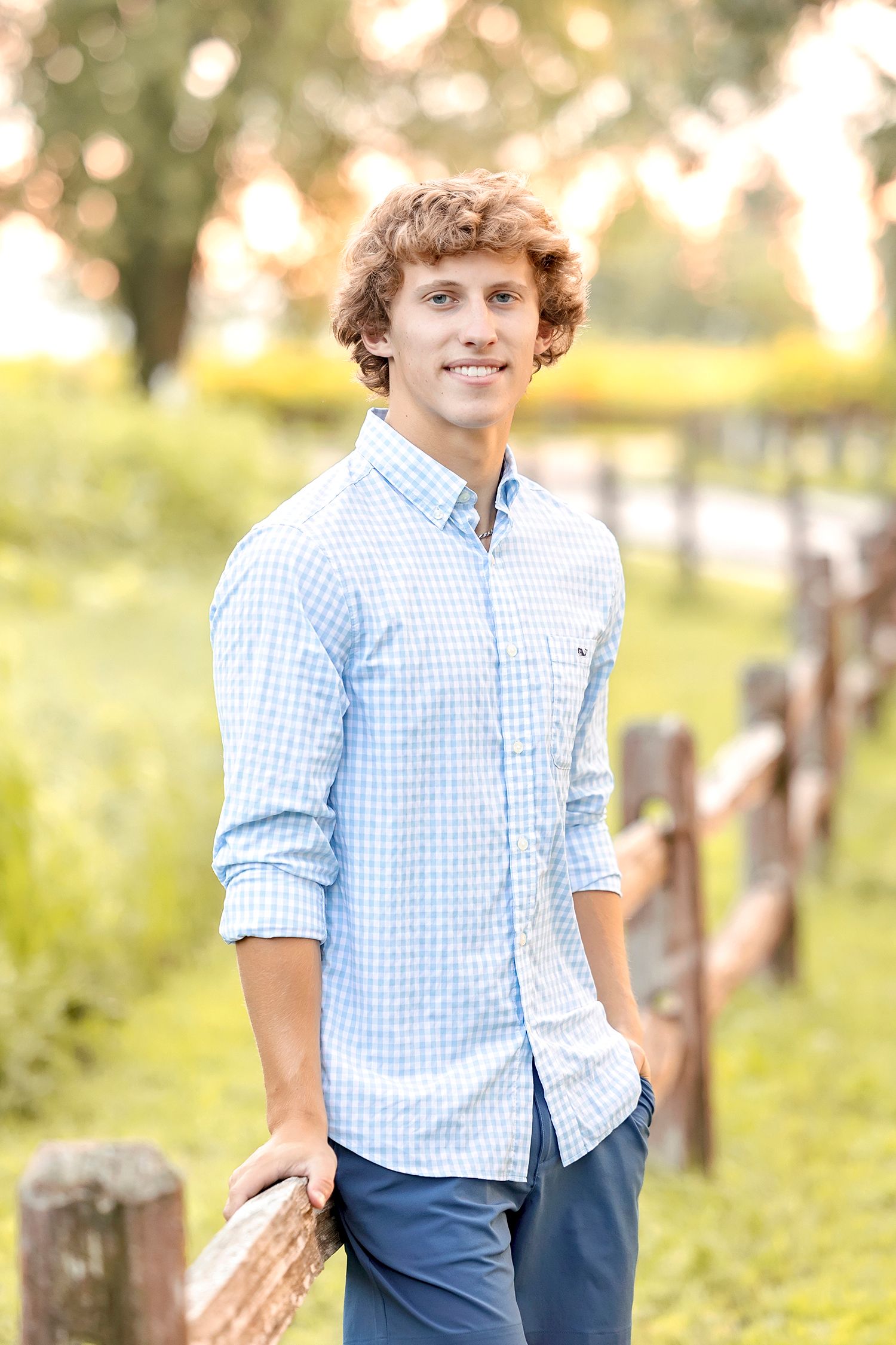 High school senior boy walking through grassy path during Clear Lake Iowa senior session