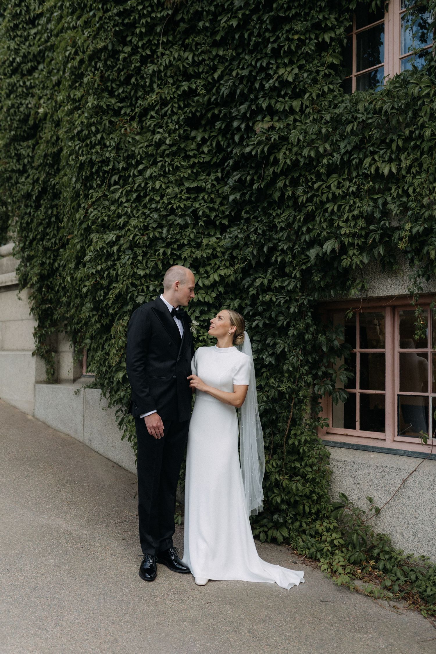 Elegant wedding reception venue with crystal chandeliers, ornate ceiling details, and round tables set for formal dining.