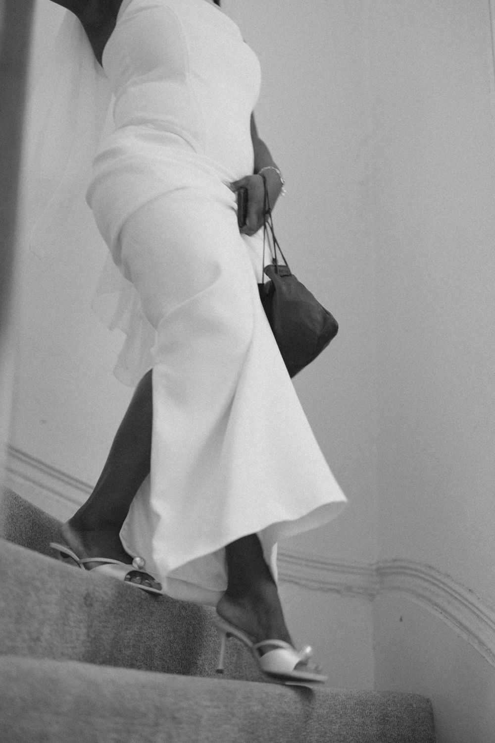 Black and white sequence showing white fabric moving down stairs in an artistic motion study.