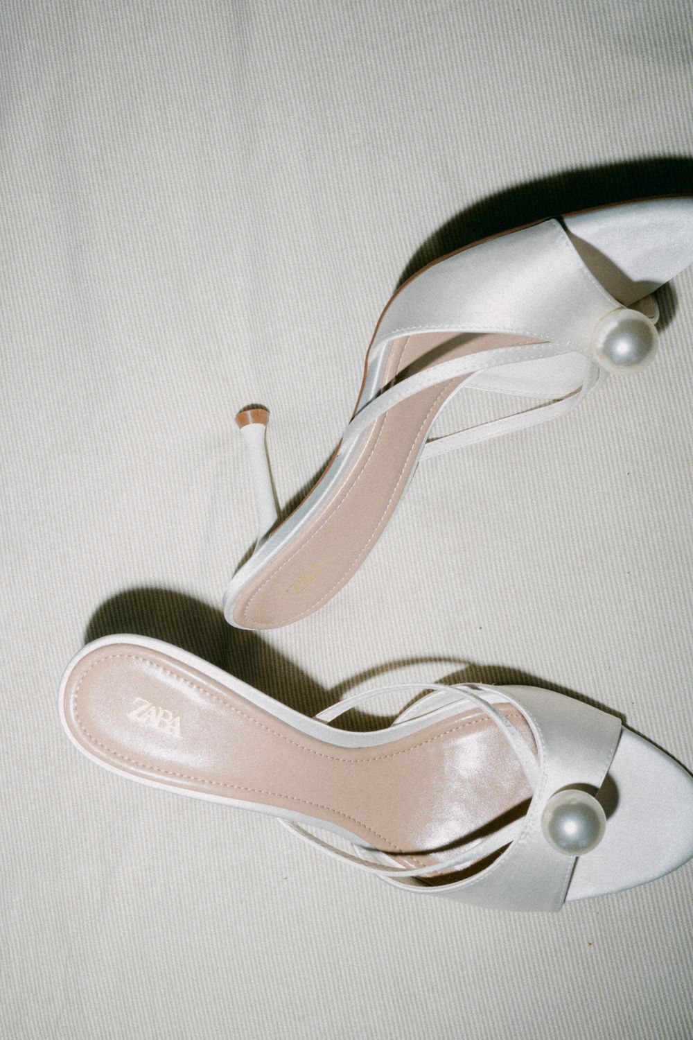 Elegant white slingback high heel shoes photographed from different angles on a light gray background.