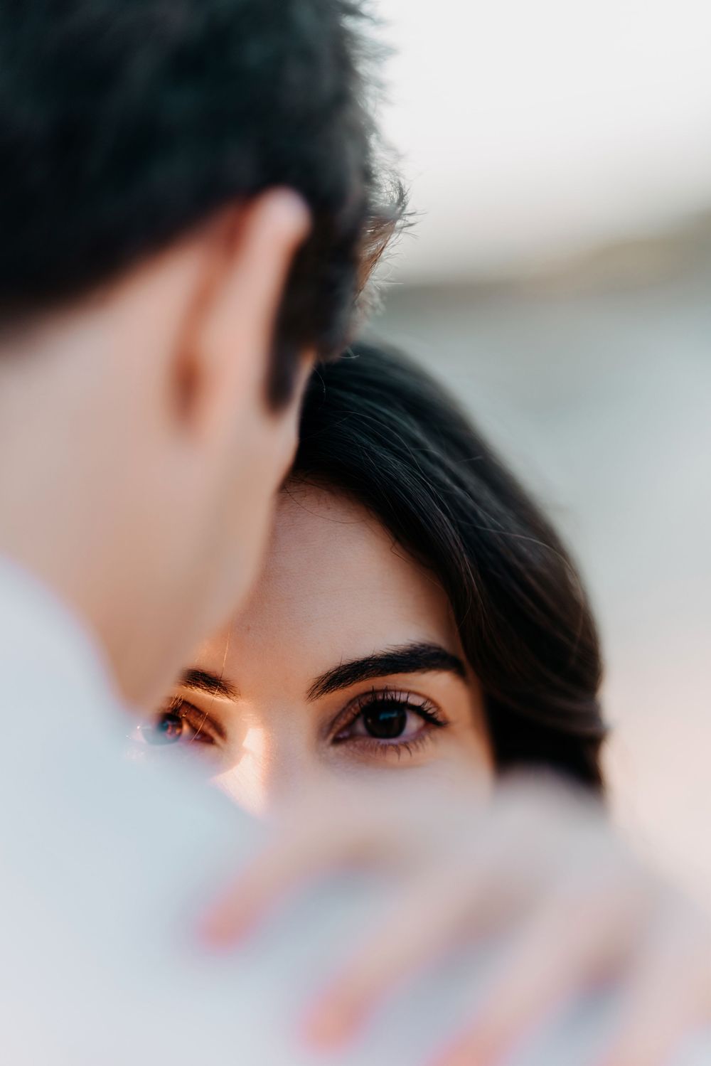 Close up artistic portrait showing eyes and dark hair with soft focus and shallow depth of field.