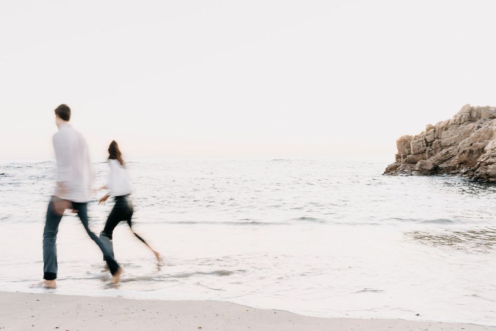 A series of five minimalist beach photographs showing people walking along the shoreline at sunset in muted tones.