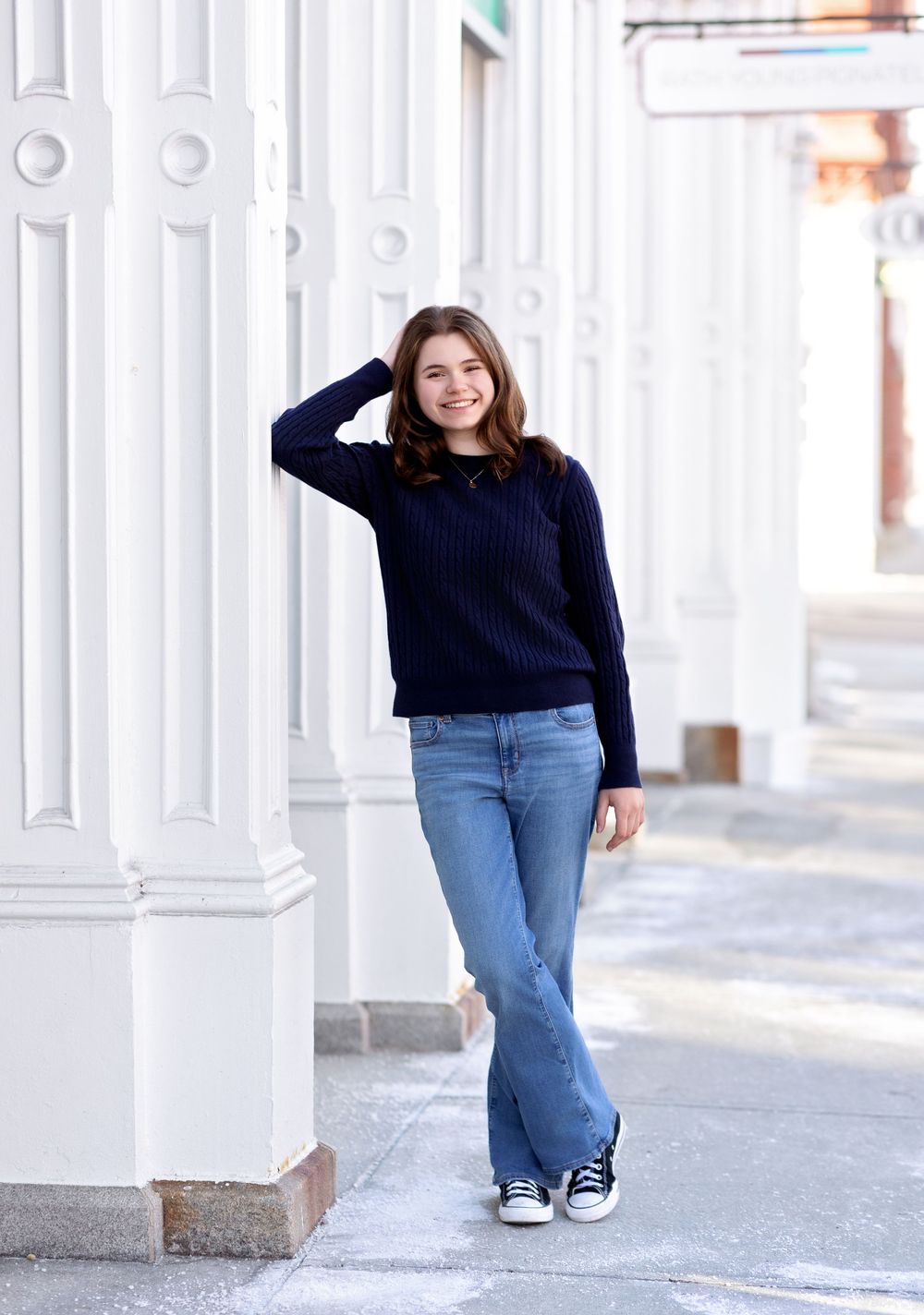 Senior girl posing under historic white columns in downtown Concord NH senior photography.