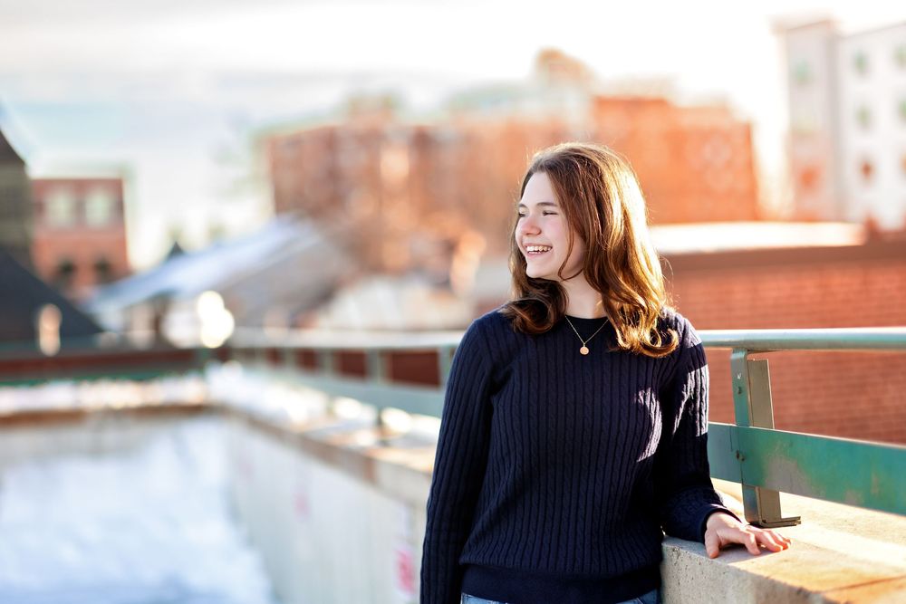Senior looking over downtown Concord NH river view during winter senior portrait session.