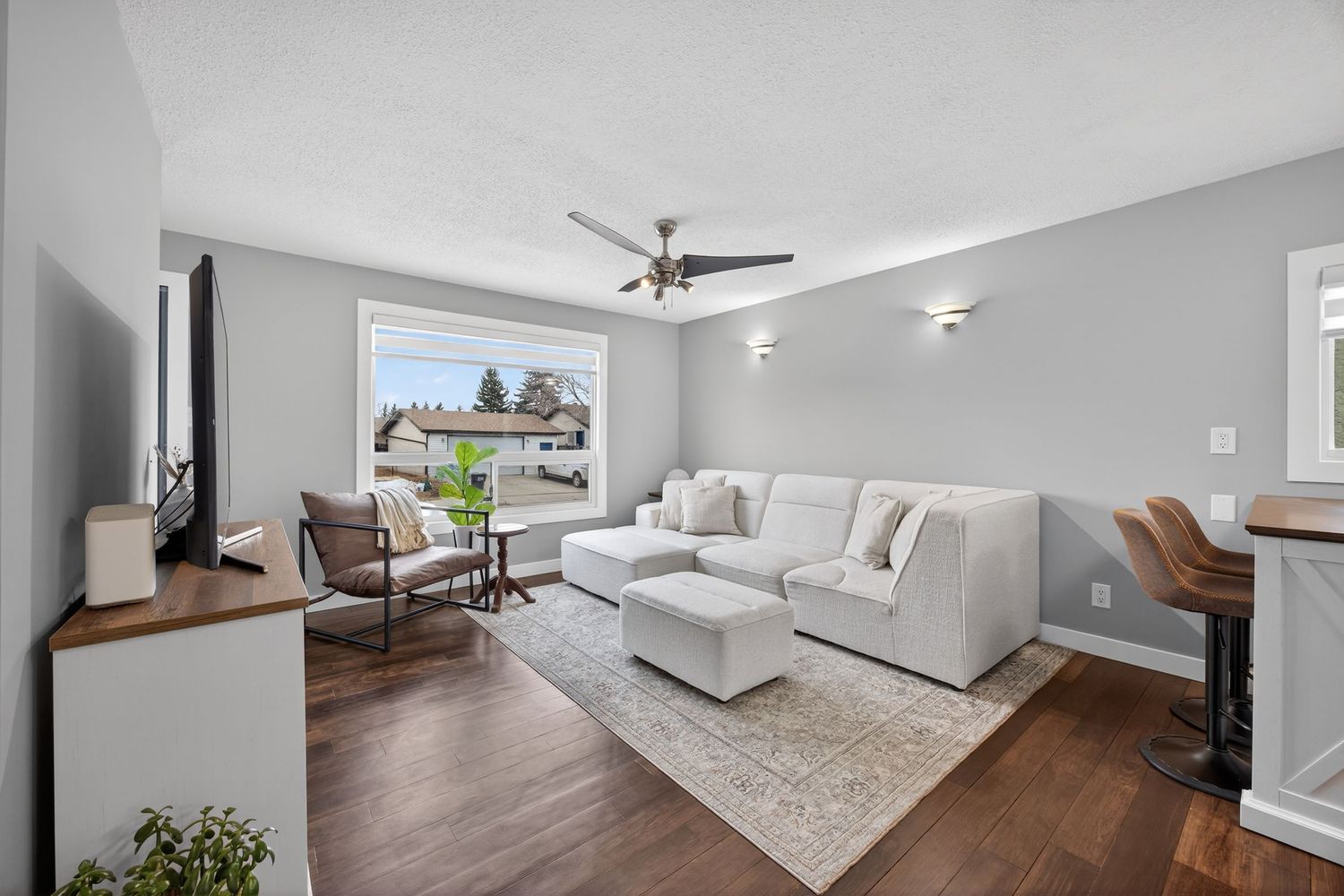 Bright open concept living space with hardwood floors and large windows offering natural light.