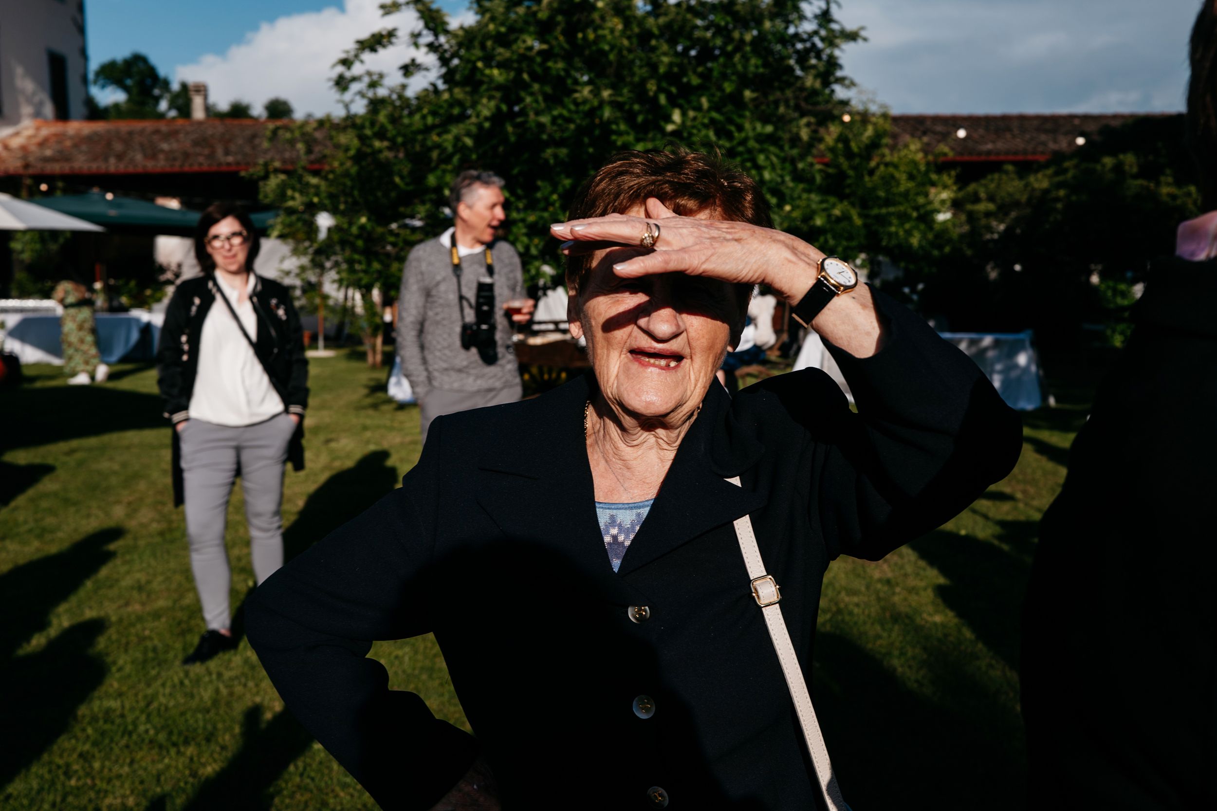 A sequence of candid moments at an outdoor wedding celebration showing guests dancing and interacting in natural sunlight.