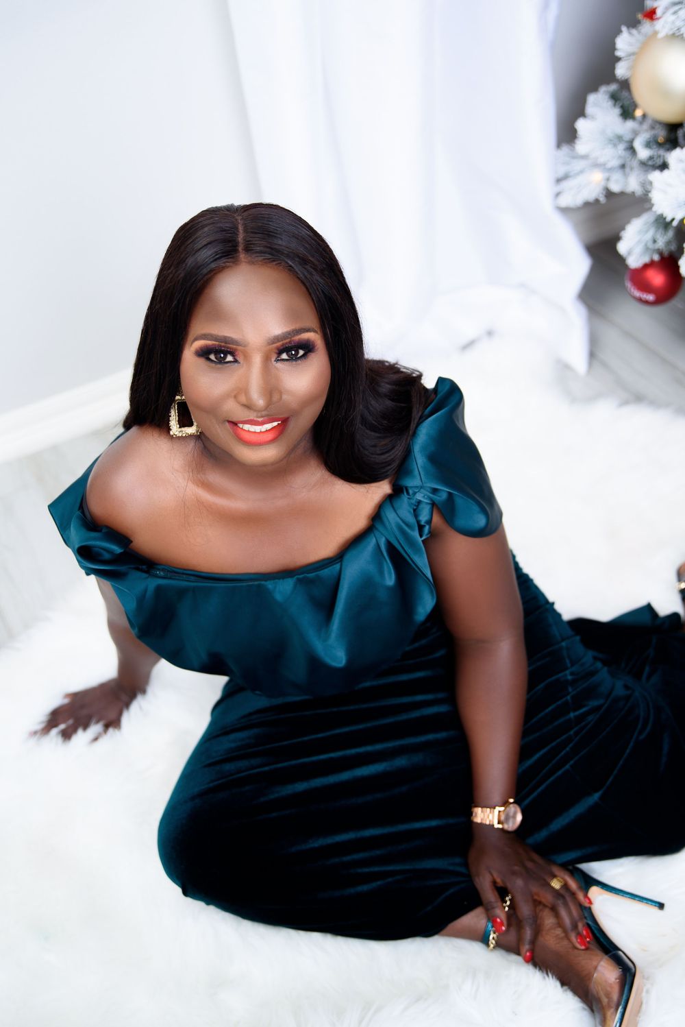 Glamour portrait session with person wearing elegant dark teal velvet gown on white backdrop.