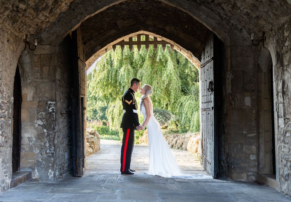 Bride and groom in medieval castle gateway